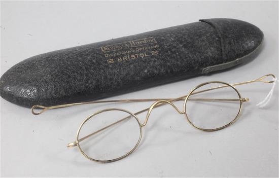 A pair of yellow metal wire-rimmed spectacles, in original opticians case